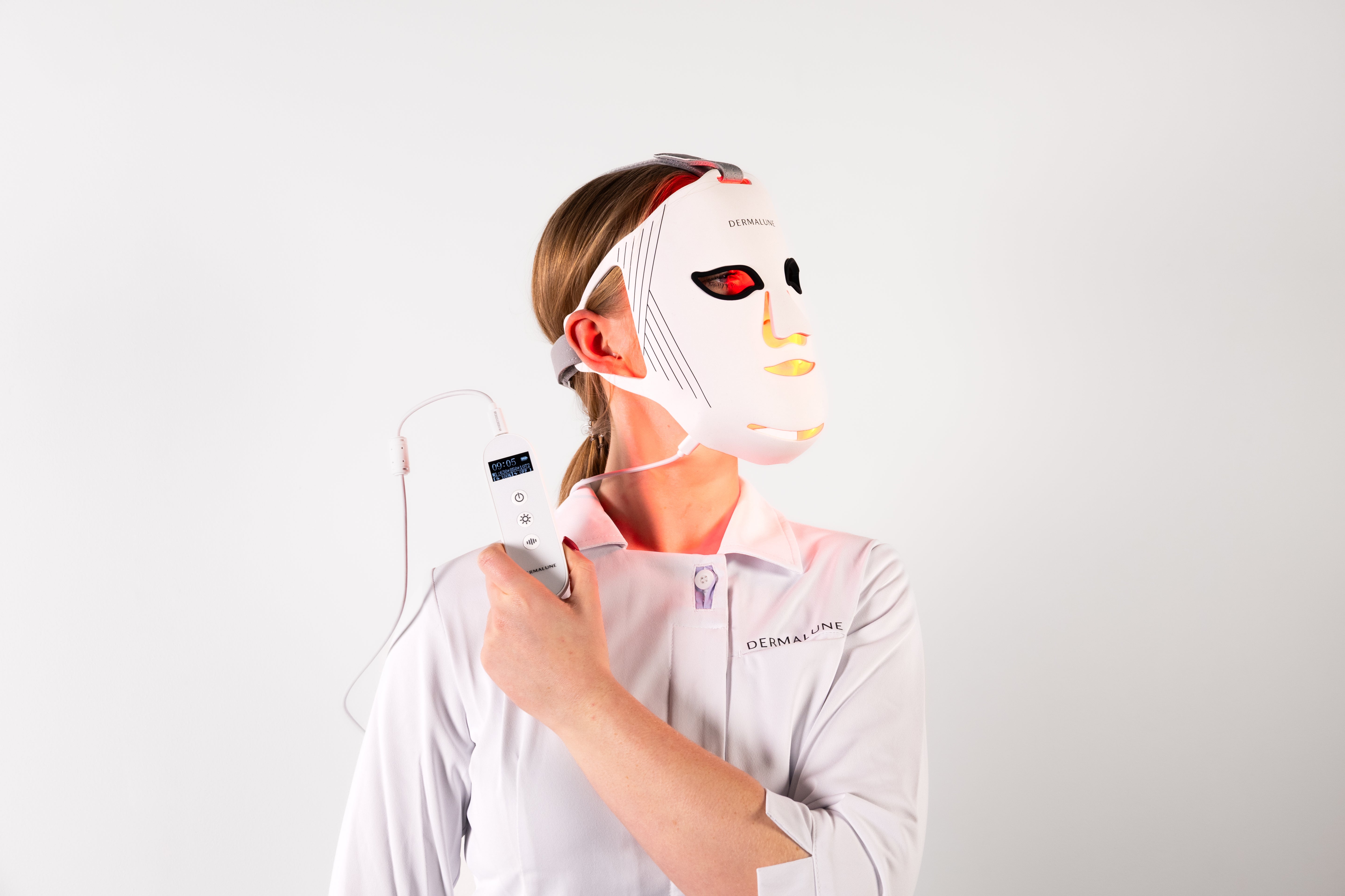 Dermalune LED photobiomodulation Mask product - professional holding remote in hand